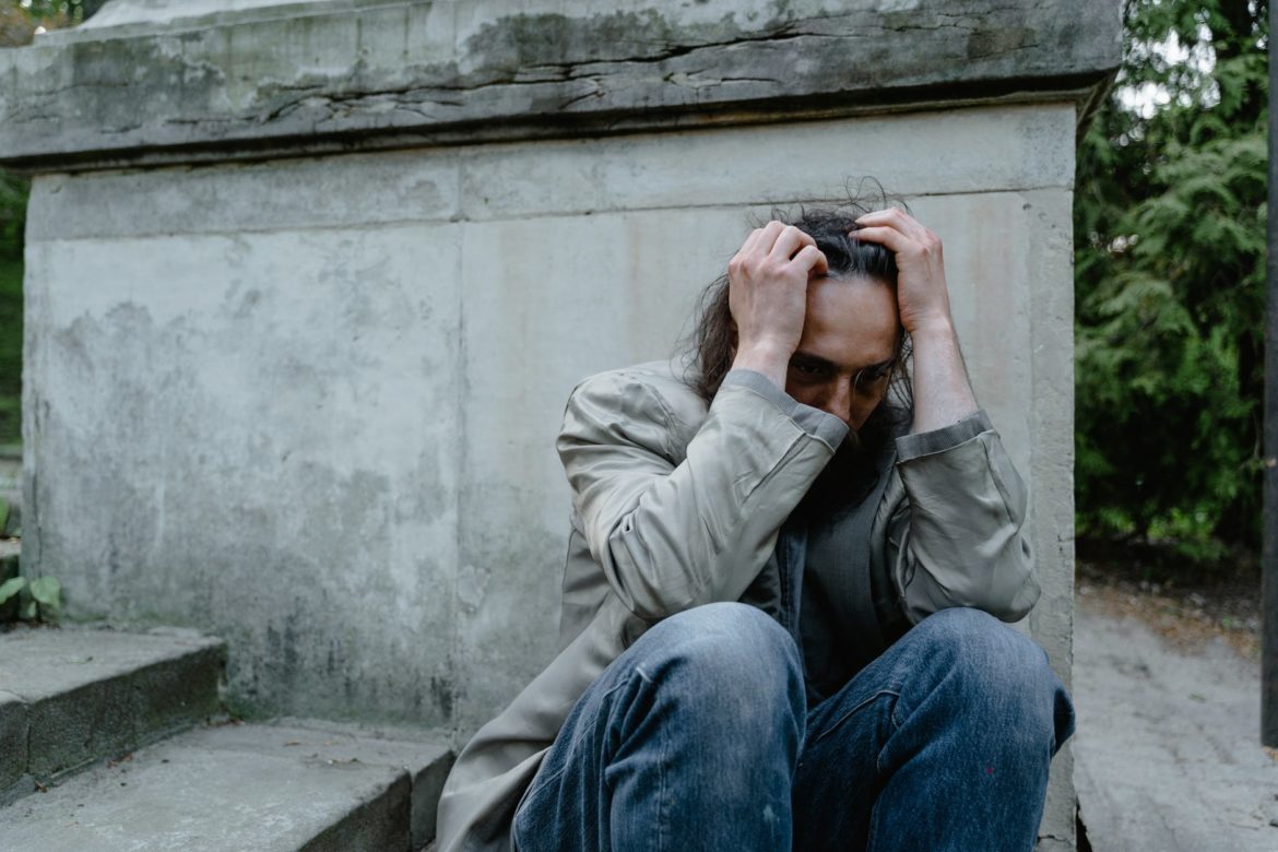 worried mad sitting on a concrete stairs