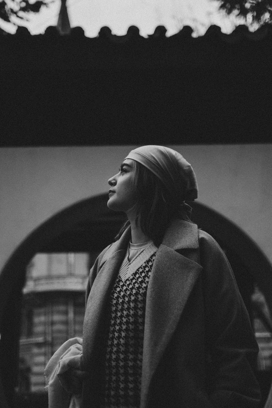 woman wearing a scarf on her head standing in front of a building